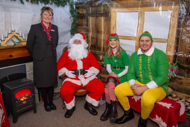 •	Linden Homes’ sales advisor Debbie Jacobs with Santa, an Elf and Buddy the Elf 