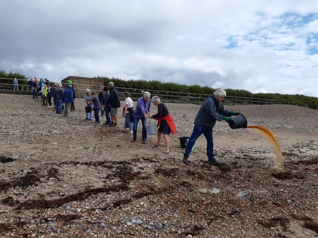 A bucket chain of volunteers from Ferring History Group and Ferring Conservation Group, including Worthing West MP Sir Peter Bottomley, form a bucket chain to bail out nine inches of water from the Ferring pillbox