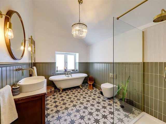 The luxury family bathroom has a walk-in shower unit and feature stand-alone roll top bath