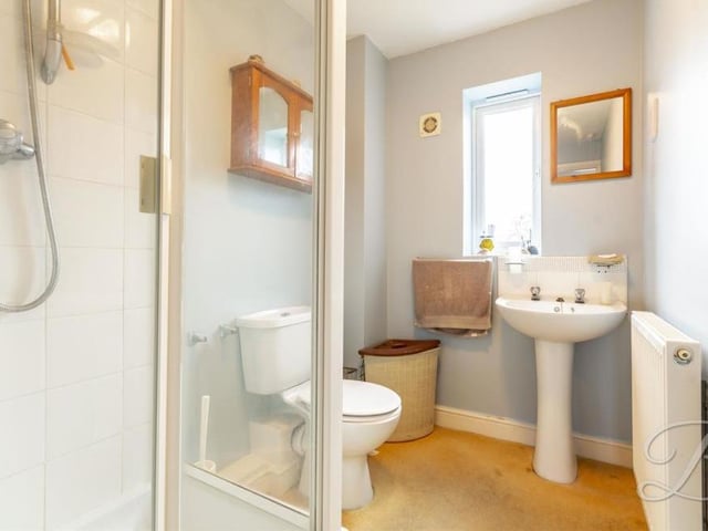 The main bedroom has the added luxury of en suite facilities. They comprise an enclosed shower, low-flush WC, pedestal sink, central heating radiator and opaque window to the back of the property.