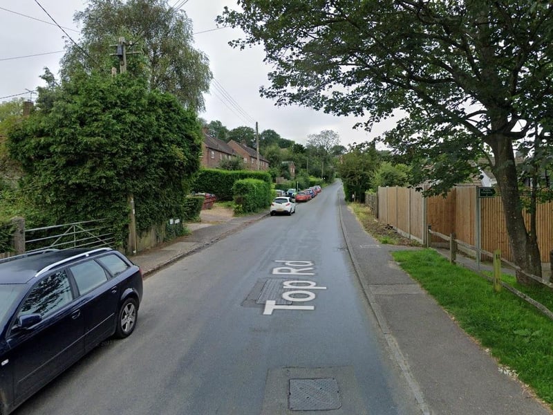An edge of a rectangular drain cover in Top Road, Sharpthorne, has eroded away, leaving a deep hole with sharp edges.