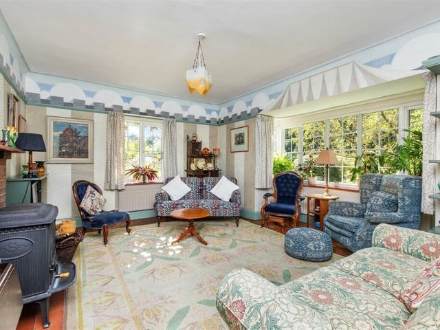 The drawing room is double aspect with a bay window and a wood burning stove in an original fireplace