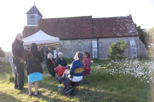 The poetry evening in Binsted churchyard in the evening sun, surrounded by beautiful countryside with waving Oxeye daisies