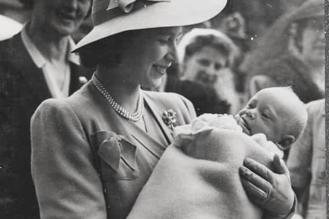 The Queen, then Princess Elizabeth, cradles Maurice Occleshaw in 1945