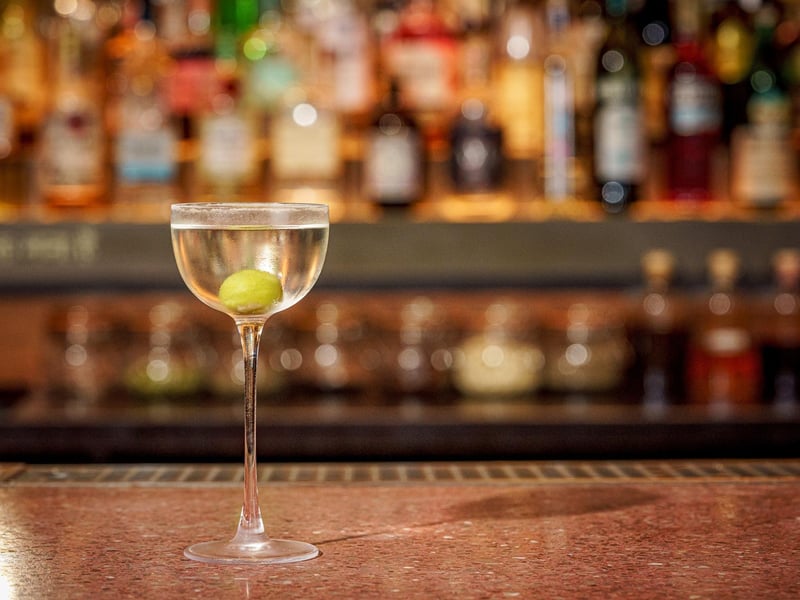 A Feni Martini - A green olive rests in a cloudy-cold mix of dry gin. Axia Extra Dry Mastiha Spirit and cashew eau de vie