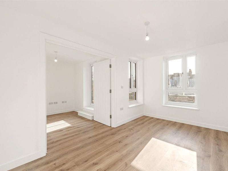 This apartment on the first floor is priced at £265,000. The open-plan layout effortlessly connects the dining area and kitchen, the bathroom has a bath and overhead shower, and there is a separate utility room.