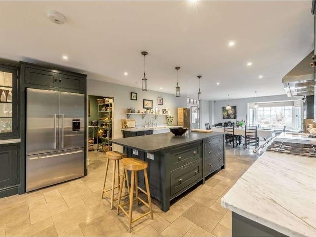 The impressive open plan kitchen/dining room and family area is the heart of the home. In the centre is a stunning bespoke solid wood kitchen providing an excellent range of painted cabinets complemented by carrera marble worktops and a dark limestone central island