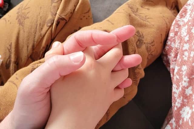 Catherine holding her foster child's hand