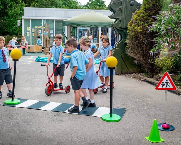 Rolls-Royce Motor Cars has donated a Road Safety Activity Kit to neighbouring March CE Primary School. Year R children are pictured learning how to cross the road safely. Photo: Rolls-Royce Motor Cars