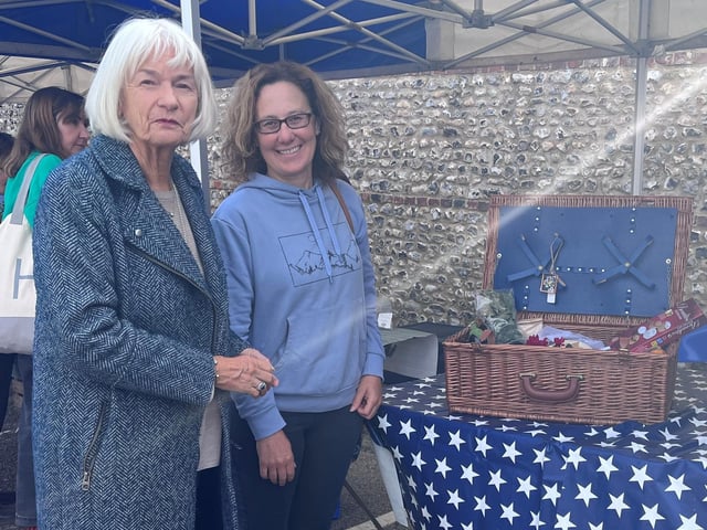 Reina Alston, left, presents the winner with the first prize in the St Barnabas House hospice hamper raffle