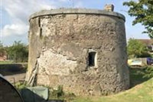 Martello tower built 1806. The moat and glacis on the east side lost. Unconnected with destruction of the moat and glacis, a small housing development was built adjacent to
the east. The preservation of archaeological and historical significance will be the main consideration in assessing the suitability of proposals to convert Martello towers for residential use.