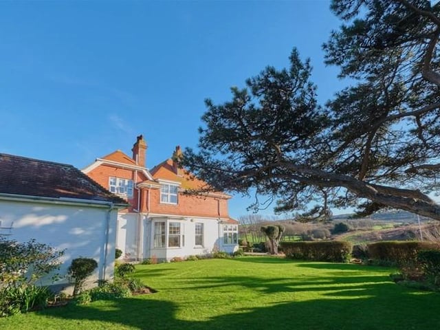 Gardens feature established flower beds and borders alongside many mature trees.
