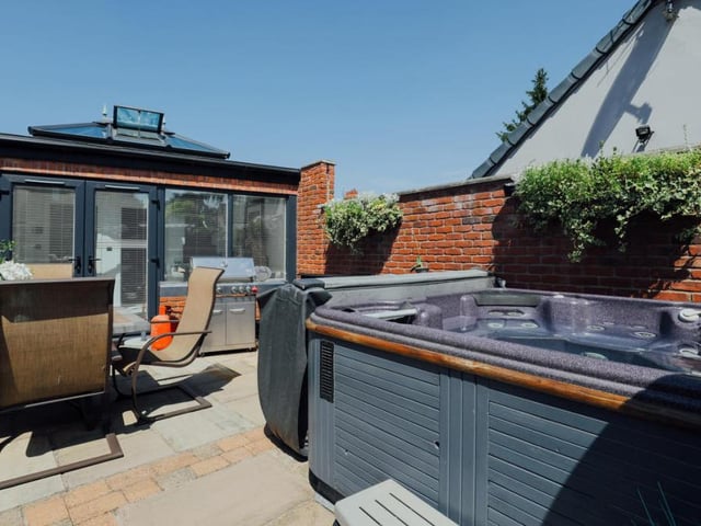 This second shot of the courtyard captures the property's hot tub. Other features include a gas fire pit and soft dusk-till-dawn floor lighting.