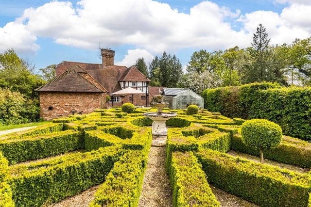 The box-hedge parterre has a classic tiered stone fountain as its centrepiece.