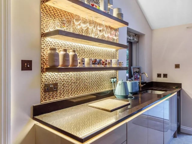 The stylish copper concave feature wall plays centre stage as too do the hanging lights over the fantastic central island.