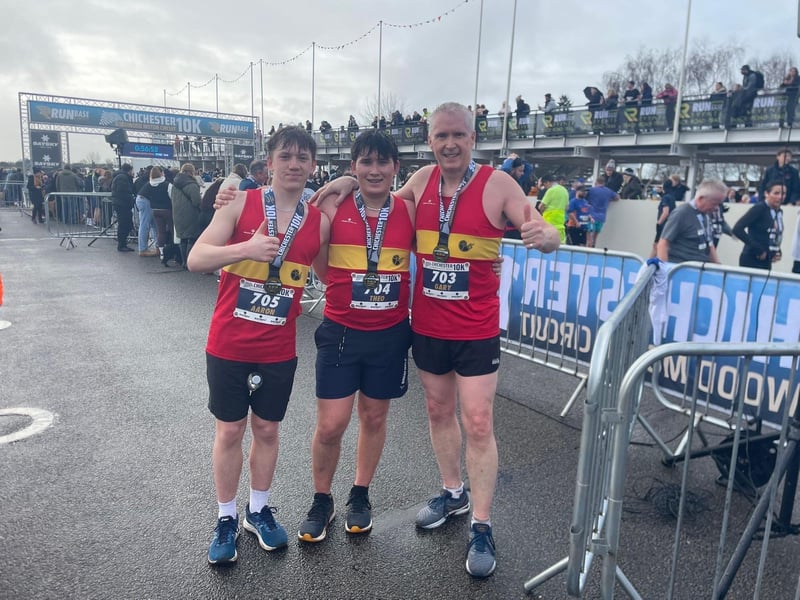 Aaron Loughlin places fifth in MU17, celebrating with his dad and brother who also took part in the Chichester 10k