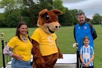Sidney Squirrel and Caroline Roberts-Quigley from Chestnut Tree House with Worthing United Youth FC Chairman Jason Nicholls and footballer Georgia Novis (aged nine).