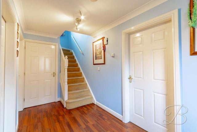 To move up to the first floor, we must return to the spacious entrance hallway, with its laminate floor, central heating radiator and carpeted staircase.