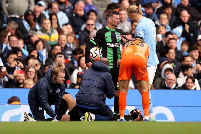 Solly March receives medical treatment as Pascal Gross speaks with Erling Haaland at Manchester City in October (Photo by Charlotte Tattersall/Getty Images)