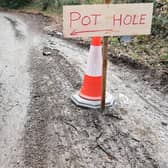 The home-made pothole sign alerting drivers to the danger on a road in Warnham near Horsham. Photo: Eddie Mitchell