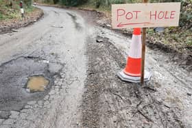 The home-made pothole sign alerting drivers to the danger on a road in Warnham near Horsham. Photo: Eddie Mitchell