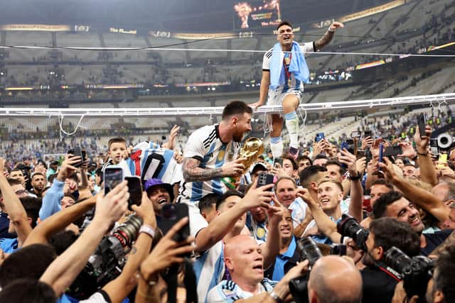 Lionel Messi of Argentina celebrates with teammates and the FIFA World Cup Qatar 2022 Winner's Trophy after the team's victory  during the FIFA World Cup Qatar 2022 Final match between Argentina and France at Lusail Stadium on December 18, 2022 in Lusail City, Qatar. (Photo by Clive Brunskill/Getty Images)