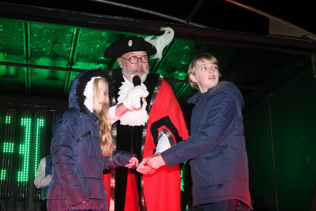 Town crier John Travers and Pixie 10 and Archie 11 switch on the lights. Photo by Derek Martin Photography and Art.