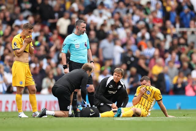 James Milner of Brighton & Hove Albion receives medical treatment before being substituted off at Arsenal