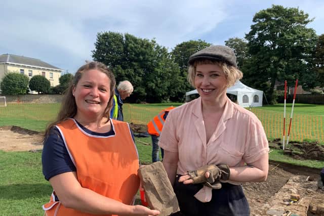 Hannah Russ and Chloe Duckworth with a brick excavated from the dig