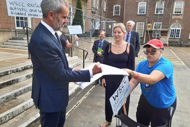 People with autism and other disabilities gathered outside County Hall, Chichester, to protest the decision to remove £250,000 of annual funding from the disability advocacy charity Impact Initiatives which helps more than 450 vulnerable people a year. Picture: Karen Dunn/Sussex World