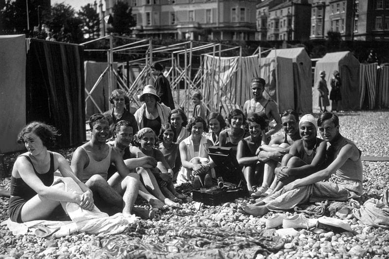 Holidaymakers on the beach at Eastbourne, listening to their gramophone in the July sunshine in 1930.
