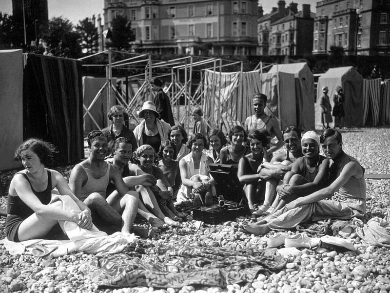 Holidaymakers on the beach at Eastbourne, listening to their gramophone in the July sunshine in 1930.