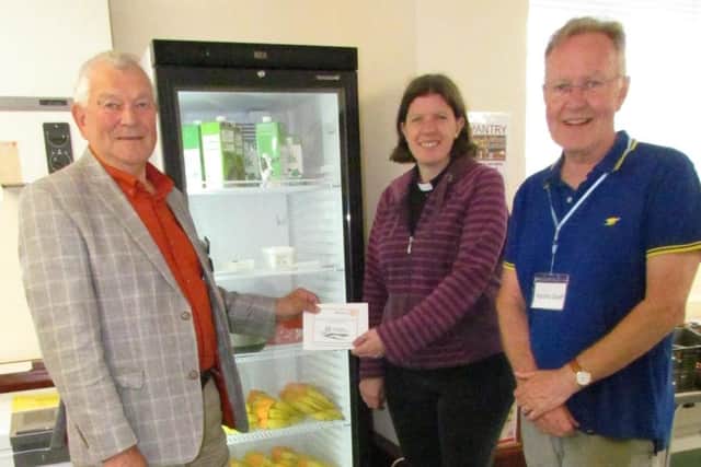 Jeremy Flasket, president of Angmering and South Downs Rotary Club, presents the donation to the Rev Natalie Loveless, watched by Charlie Sims