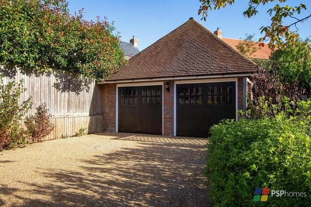 A brick pathway leads to the detached double garage