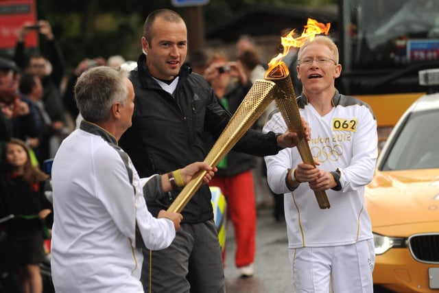 A new torch is lit as runners hand over on the Olympic torch relay in Bognor Regis