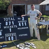 Ryan Welch next to the scoreboard after he hit 411 not out for Willingdon