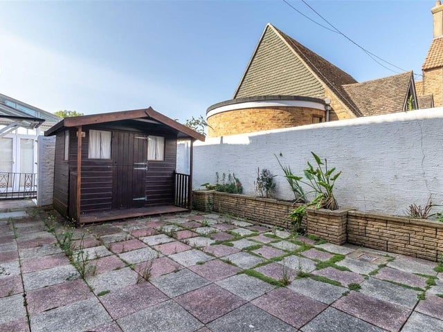 The garden has a timber potting shed and a gate providing side access