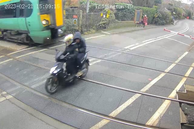 The moped rider and passenger narrowly missed getting hit by a train after they dodged the level crossing barrier