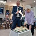 Resident Patricia Measurers cutting the cake with Regional Director Jeff Levine 