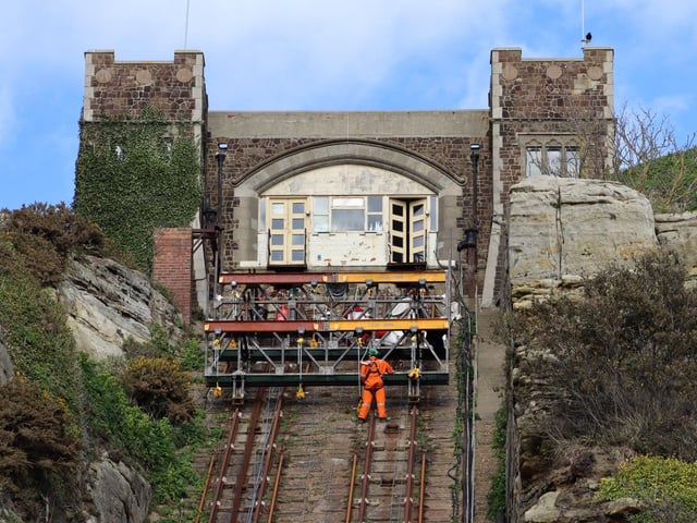 Workers using special safety harnesses on the near vertical cliff railway