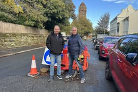 Cllrs Graeme Williams and Andy Patmore standing next to the sinkhole in Pevensey Road
