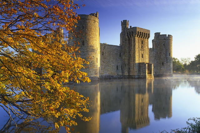 A slight mist rises from the moat at dawn at fourteenth century Bodiam Castle, East Sussex.