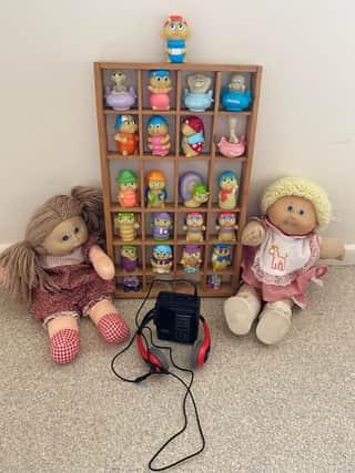 Toys from the 80s - a selection of glow bugs, cabbage patch kids and a cassette Walkman.