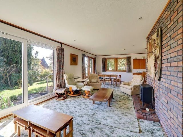 The lounge / diner has an open fireplace with brick-built surround and shelving