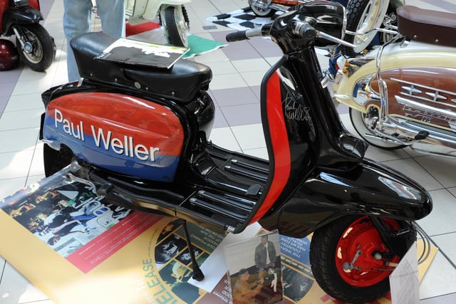 A scooter signed by musician Paul Weller, with a photo of the moment he penned his name