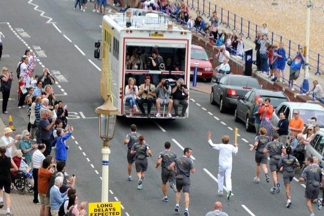 Local residents and students packed the streets, waving flags next to custom stalls as they saw the famed torch pass by the seafront.
