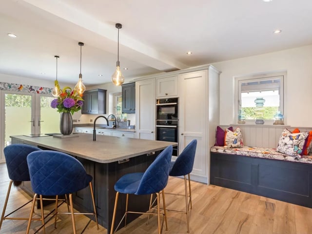 There is an impressive modern kitchen with fitted units and a large central island