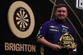Luke Littler poses with the trophy after beating Nathan Aspinall of England to win the final of the 2025 BetMGM Premier League Darts at Brighton Centre in 2025 (Photo by Warren Little/Getty Images)