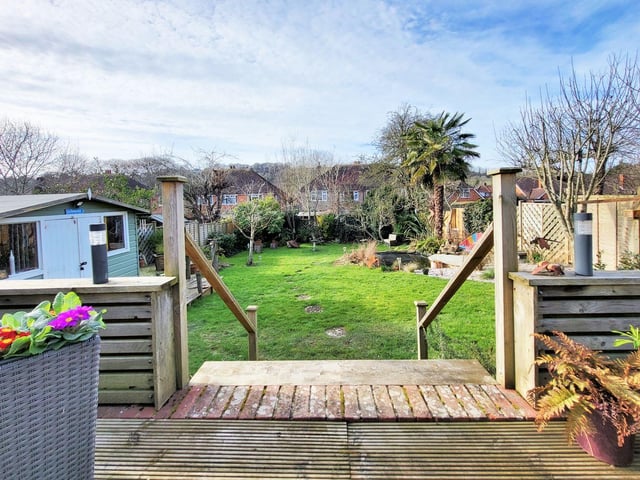The Maytree Avenue bungalow has a large, west-facing rear garden with decked area for seating, steps leading down to the lawn with pond, shed/workshop with power, and further decked area.