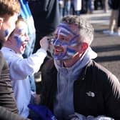 A family of Brighton & Hove Albion fans apply face paint outside the stadium prior to the Premier League match between Brighton & Hove Albion and Aston Villa